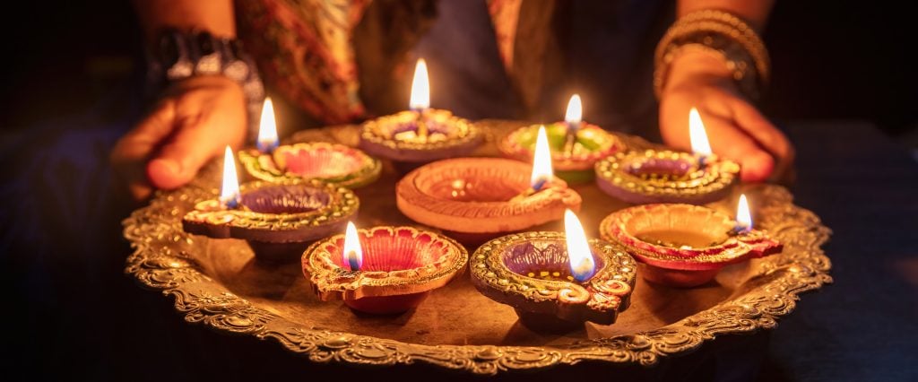 Tray with Diya oil lamps lit at a Deepavali celebration. (Rawf8/iStock/Getty Images Plus)