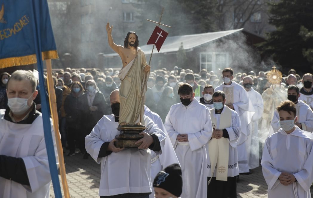 Catholic priest carries a statue of Jesus Christ as he walks in religious procession during the Holy Easter celebration in the Cathedral of the Immaculate Conception in Moscow, Russia, Sunday, April 4, 2021. (AP Photo/Pavel Golovkin)