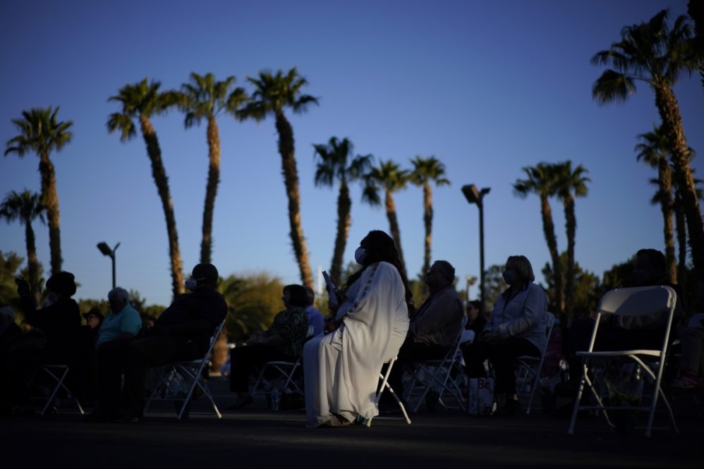 People attend an Easter sunrise service at the Palm Eastern Mortuary and Cemetery, Sunday, April 4, 2021, in Las Vegas. (AP Photo/John Locher)
