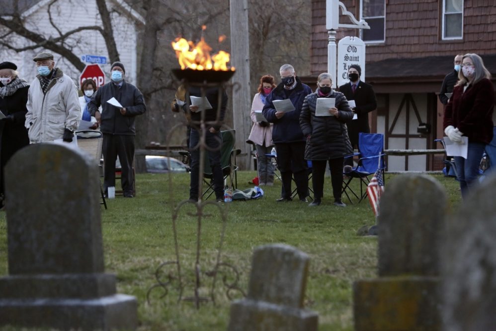Parishioners of St. Paul's Episcopal Church stand to worship during an Easter sunrise service held on the burial grounds outside of Old St. Luke's Church in Carnegie, Pa., on Sunday, April 4, 2021. For many congregants, this was the first in-person worship service they have attended since the coronavirus surge in November. (AP Photo/Jessie Wardarski)