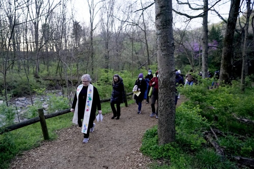Rev. Beth Smith McCaw leads worshipers on a walk through the woods to their Easter Sunday sunrise service at Radnor Lake State Park Sunday, April 4, 2021, in Nashville, Tenn. Their annual sunrise service at the lake did not take place in 2020 because of COVID-19, but the church decided to reinstate it this year. (AP Photo/Mark Humphrey)