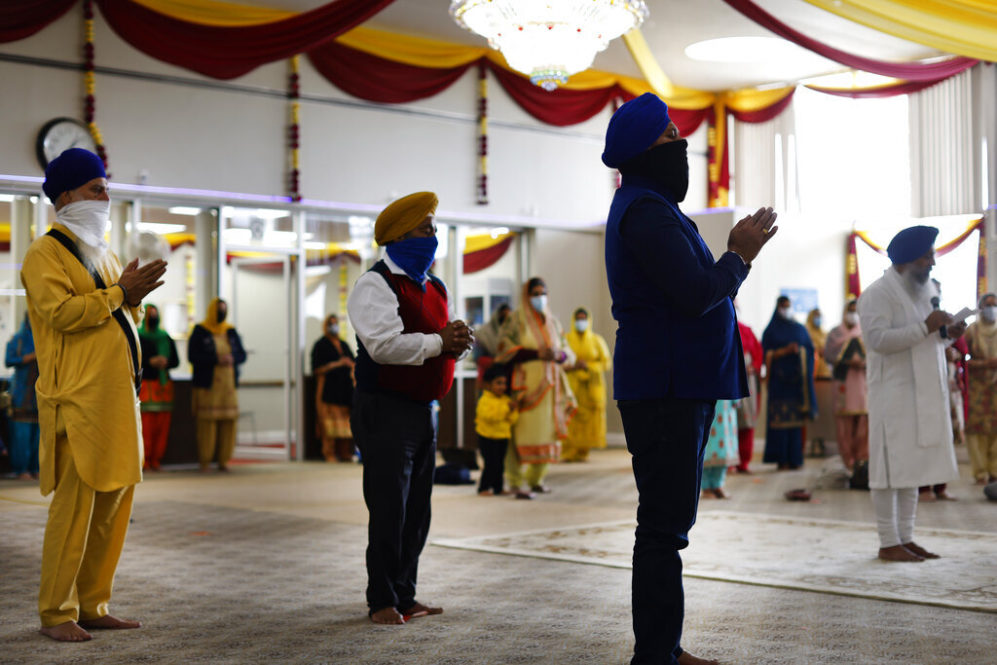 Sikhs pray during Vaisakhi celebrations at Guru Nanak Darbar of Long Island, Tuesday, April 13, 2021 in Hicksville, N.Y. Sikhs across the United States are holding toned-down Vaisakhi celebrations this week, joining people of other faiths in observing major holidays cautiously this spring as COVID-19 keeps an uneven hold on the country. (AP Photo/Jason DeCrow)