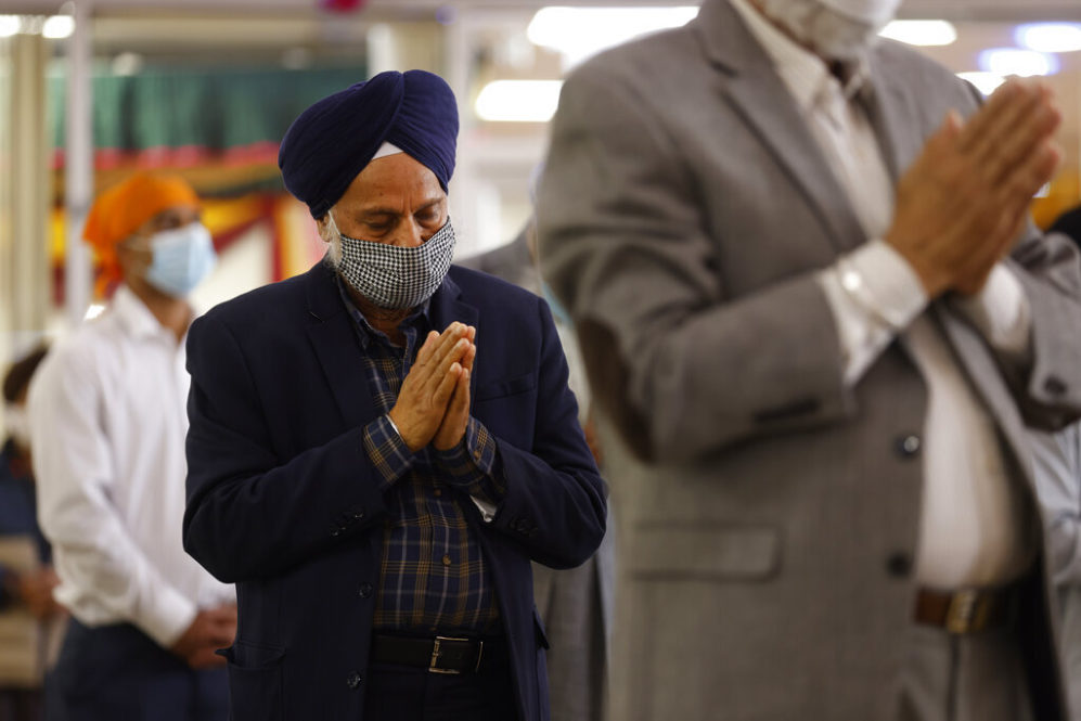 Sikhs pray during Vaisakhi celebrations at Guru Nanak Darbar of Long Island, Tuesday, April 13, 2021 in Hicksville, N.Y. Sikhs across the United States are holding toned-down Vaisakhi celebrations this week, joining people of other faiths in observing major holidays cautiously this spring as COVID-19 keeps an uneven hold on the country. (AP Photo/Jason DeCrow)