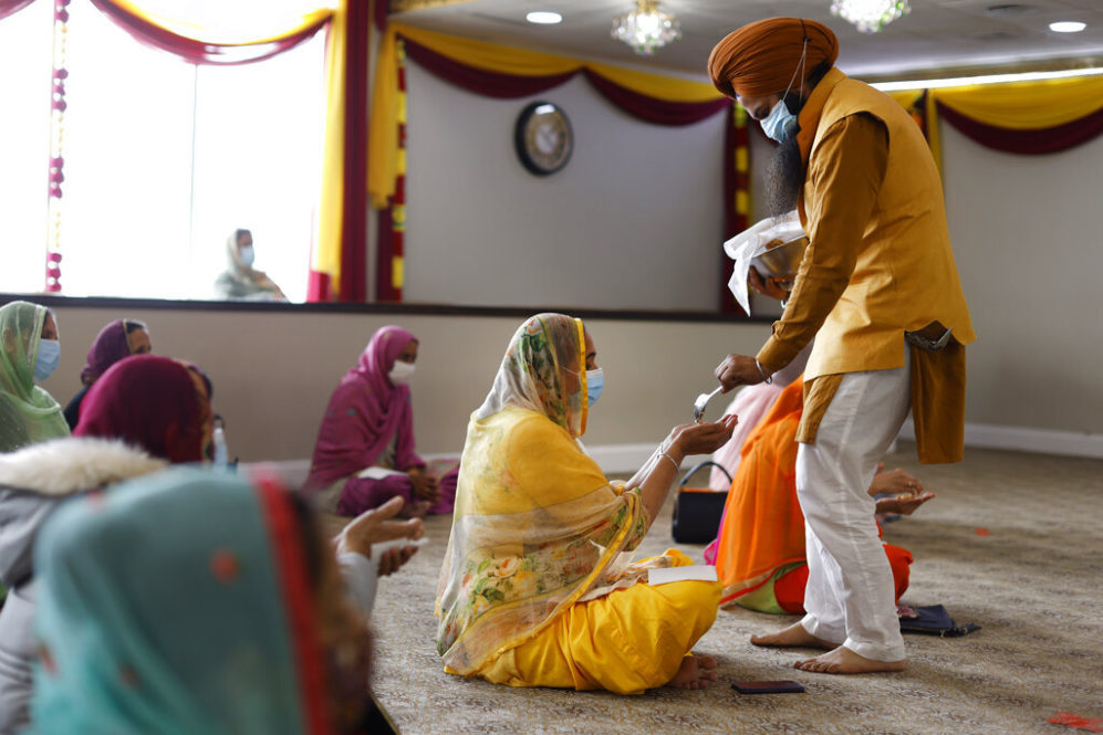 Kraa prashaad is handed out during Vaisakhi celebrations at Guru Nanak Darbar of Long Island, Tuesday, April 13, 2021 in Hicksville, N.Y. Sikhs across the United States are holding toned-down Vaisakhi celebrations this week, joining people of other faiths in observing major holidays cautiously this spring as COVID-19 keeps an uneven hold on the country. (AP Photo/Jason DeCrow)