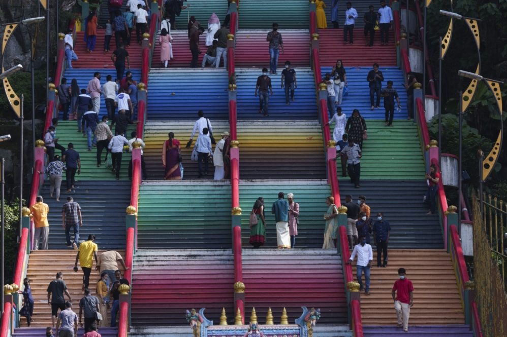 Hindu devotees climb the colored stairs to pray at the Batu Caves temple during the Hindu festival of lights, Diwali, in Kuala Lumpur, Malaysia, Thursday, Nov. 4, 2021. Diwali is one of Hinduism's most important festivals, dedicated to the worship of the goddess of wealth Lakshmi. (AP Photo/Vincent Thian)