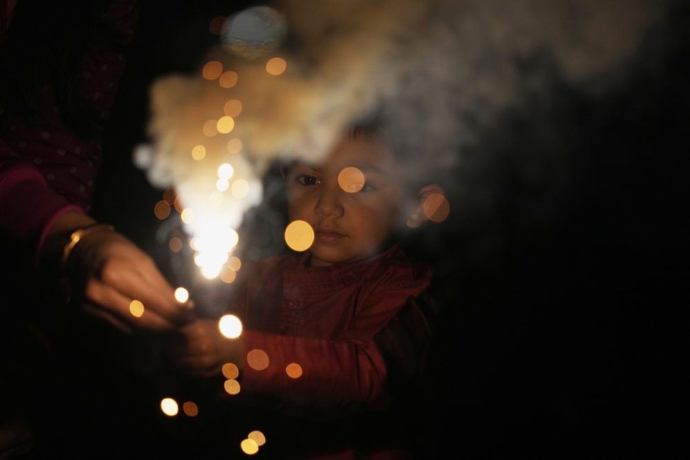 Pathik Bhalodiya, 4, gets help from his mother Shital, members of an Indian family living in Japan, to hold a piece of firework as they celebrate Diwali, the Hindu festival of lights, at a park in Tokyo, Thursday, Nov. 4, 2021. The festival is celebrated mainly in India but Hindus across the world, particularly in other parts of Asia, also gather with family members and friends to socialize, visit temples and decorate houses with small oil lamps made from clay. (AP Photo/Hiro Komae)