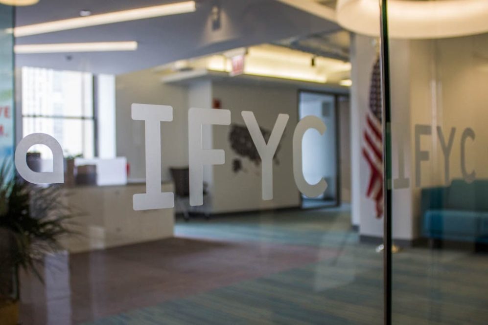 IFYC logo on glass door in office space