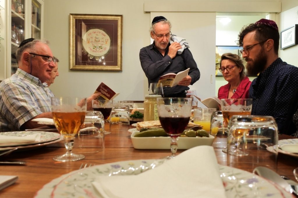 Jewish family reading the Haggadah during Passover. (ChameleonsEye/Shutterstock)