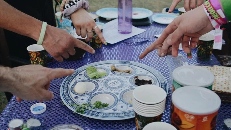 People surround a Seder plate at the Shabbat Tent at the Coachella music festival. Photo via Instagram/@chrism_arts