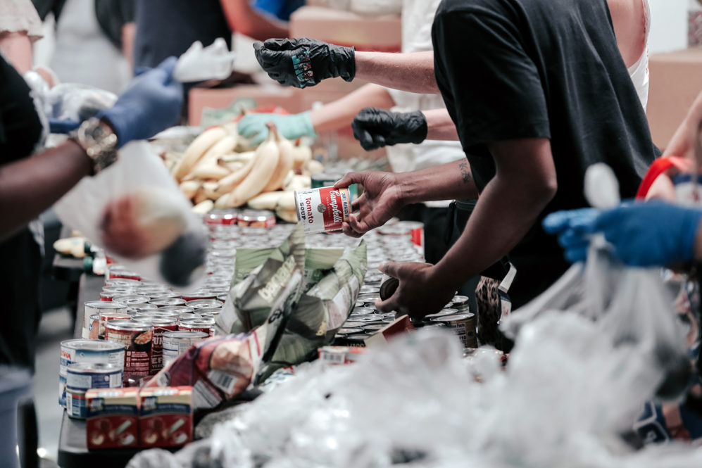 Community members work together organizing food donations. Photo by Joel Muniz/Unsplash/Creative Commons