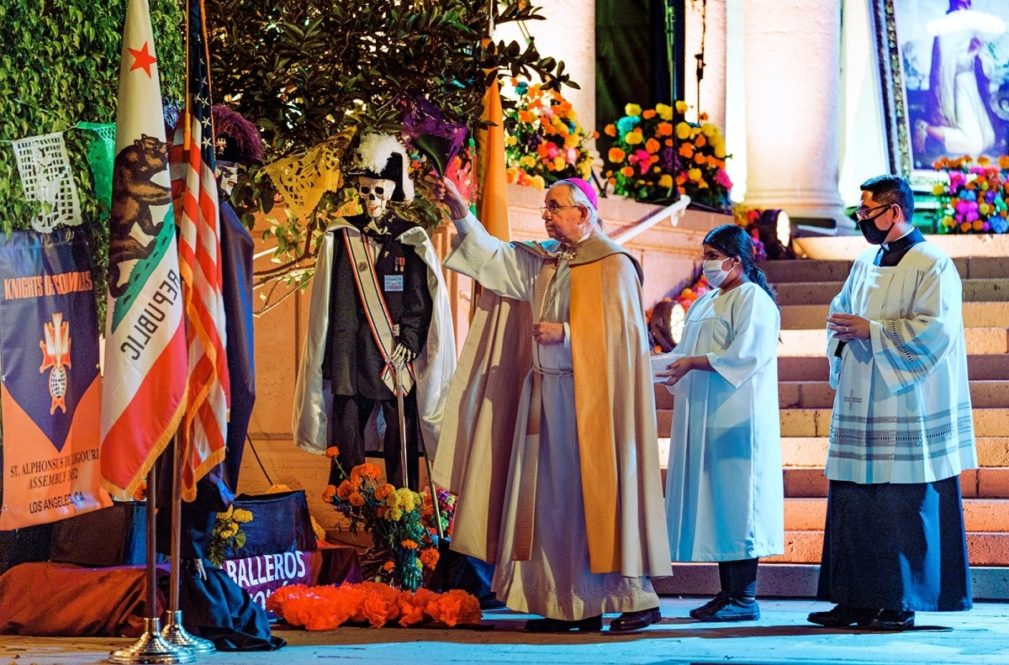 Los Angeles Archbishop José H. Gomez blesses an altar for the Knights of Columbus, Caballeros de Colon, in the outdoor courtyard of the Mausoleum of Calvary Cemetery and Mortuary in East Los Angeles, Sunday, Nov. 1, 2020. Day of the Dead, or Dia de Los Muertos, is the annual Mexican tradition of reminiscing about departed loved ones with colorful altars, or ofrendas. (AP Photo/Damian Dovarganes)