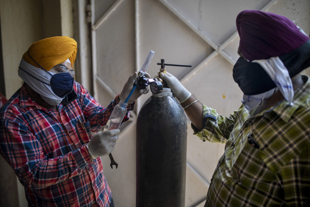 Volunteers from a gurdwara, a Sikh house of worship, prepare oxygen cylinders for patients in New Delhi on April 24, 2021. India’s medical oxygen shortage has become so dire that this gurdwara began offering free breathing sessions with shared tanks to COVID-19 patients waiting for a hospital bed. (AP Photo/Altaf Qadri)