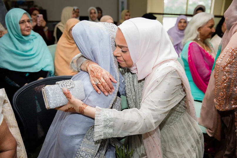 A bride, left, is hugged during a 2019 Muslim wedding at the Islamic Foundation in Villa Park, Illinois. Photo by Fariha Wajid Photography