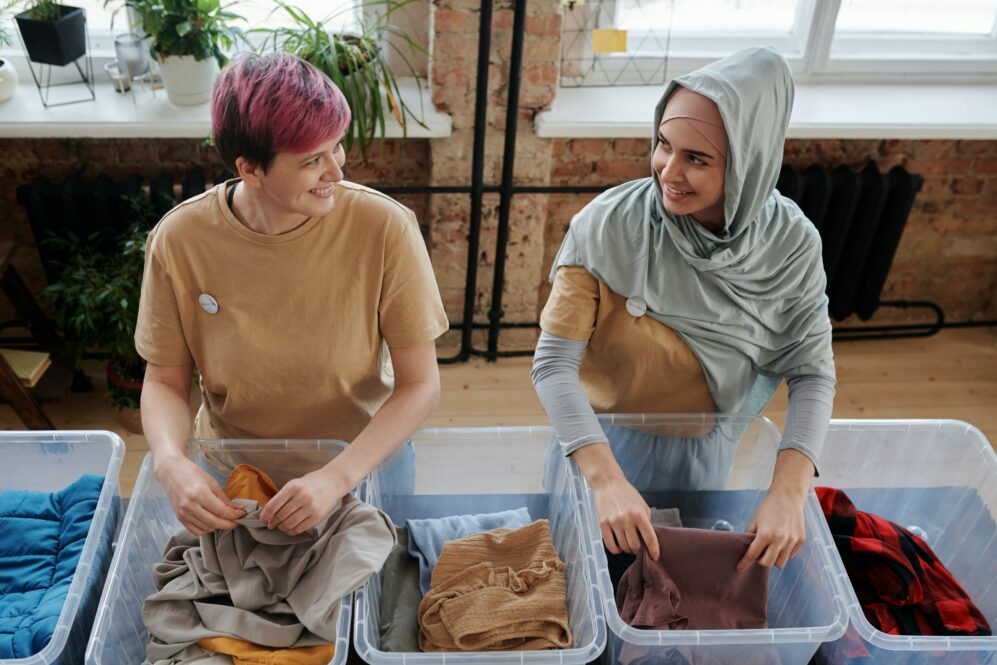 Women sorting clothes as volunteers.