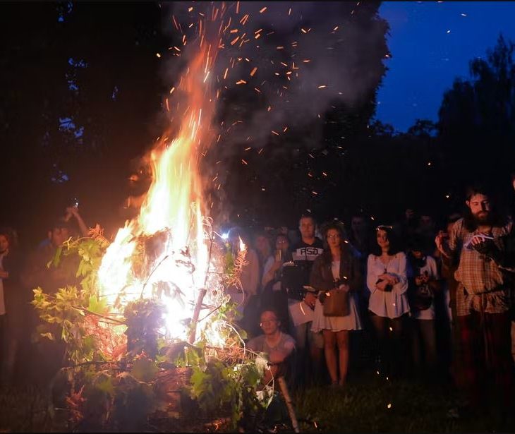 People stand around fire at night