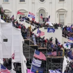 Trump supporters climb inauguration scaffolding outside the Capitol on Jan. 6, 2021, in Washington. (AP Photo/John Minchillo)