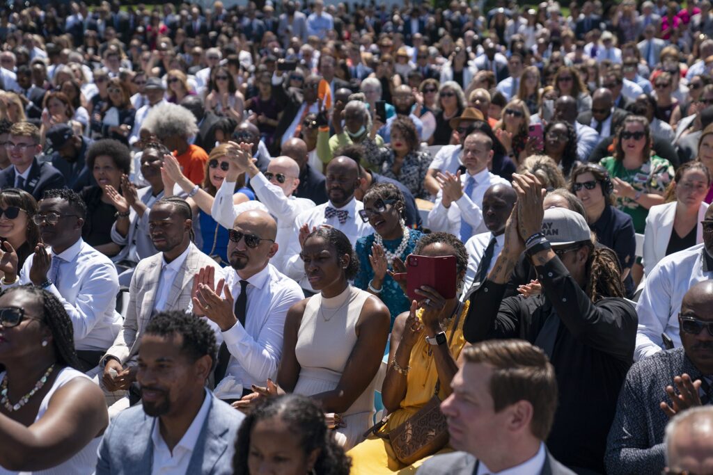 Audience members listen as President Joe Biden speaks during an event to celebrate the passage of the "Bipartisan Safer Communities Act," a law meant to reduce gun violence, on the South Lawn of the White House, Monday, July 11, 2022, in Washington. (AP Photo/Evan Vucci)