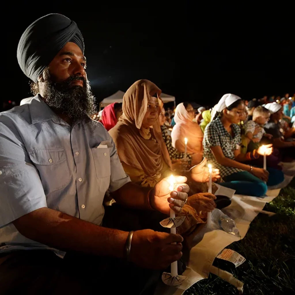 Raghu Vinder listens to speakers during a vigil at the Sikh Temple of Wisconsin on Aug. 5, 2013. (AP Photo/Morry Gash)