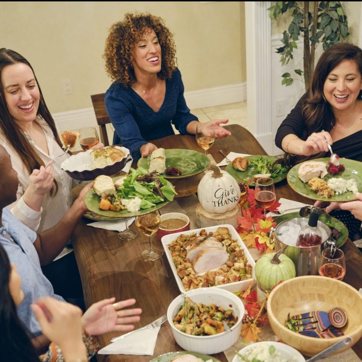Group of friends having conversation around a Thanksgiving table. Whether fun conversation or difficult interactions, Thanksgiving can be a place for deepening relationships and finding understanding.
