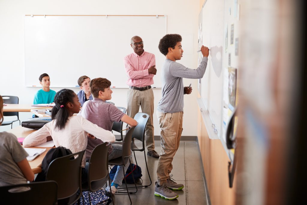 High school educator in classroom with students. (Monkey Business Images/Shutterstock)