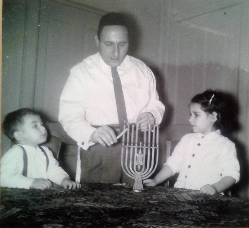 The author’s uncle, grandfather and mother lighting the Hanukkiah in 1959 in Chicago. (Courtesy photo)
