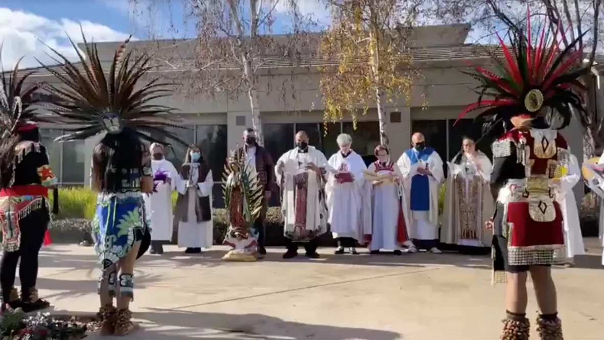 Aztec dancers bless a statue of the Virgin of Guadalupe, center, on Sunday, Dec. 11, 2022, before a service at Iglesia Luterana Santa María Peregrina in California’s Central Valley. Video screen grab