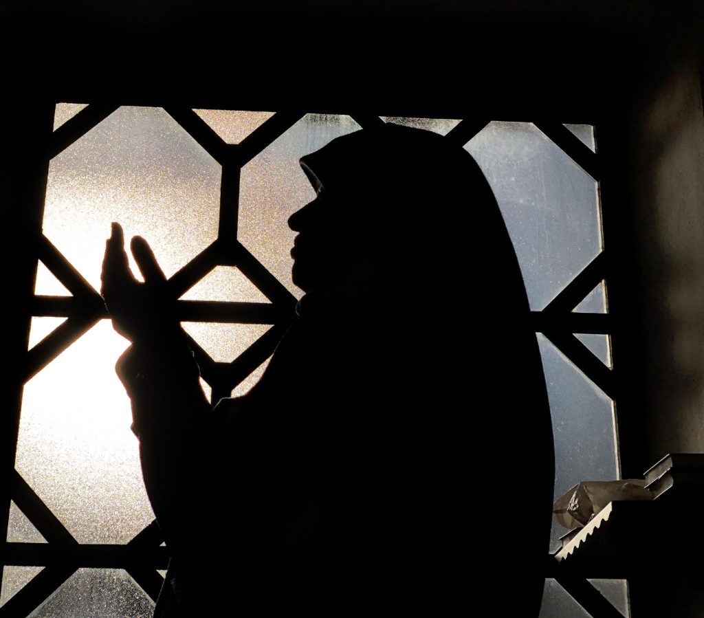 Muslim woman praying silhouette on window. (	Jasmin Merdan/Getty Images)