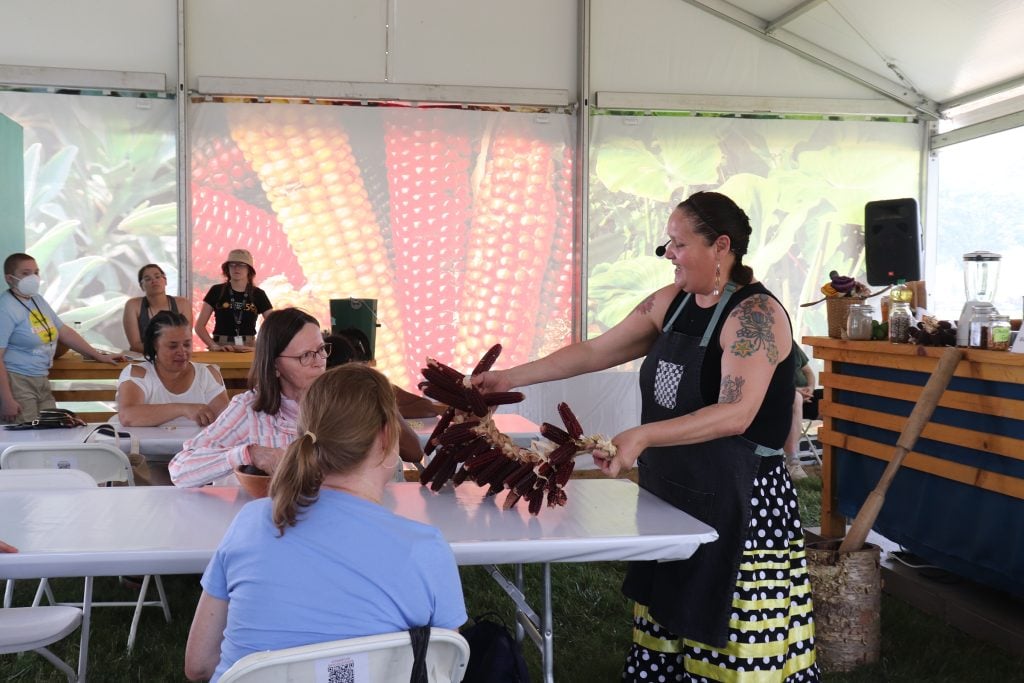 Elena Terry, right, teaches about corn in the “Kitchen Theology” tent during the annual Smithsonian Folklife Festival, Thursday, June 29, 2023, on the National Mall in Washington. RNS photo by Adelle M. Banks