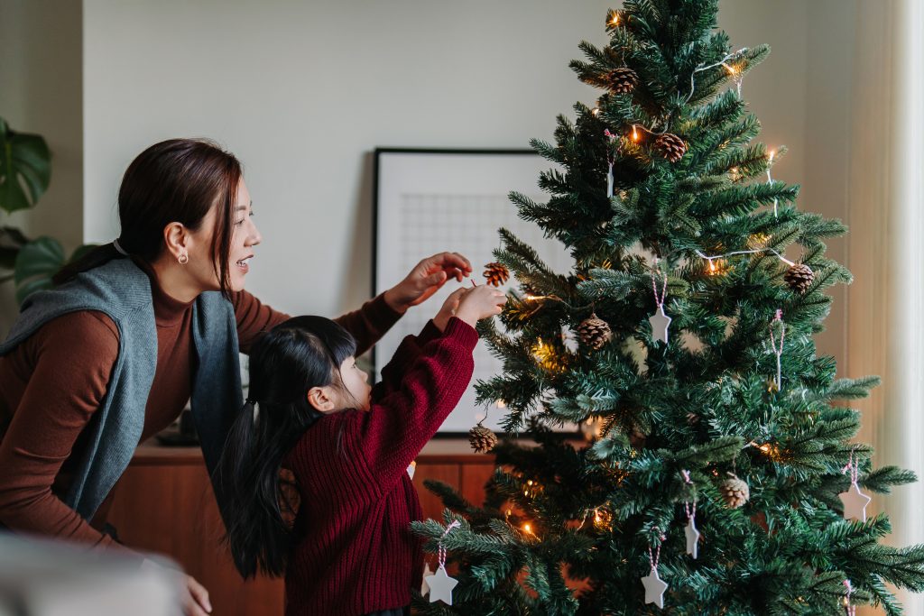 Family decorating Christmas tree at home together. (d3sign/Getty Images)