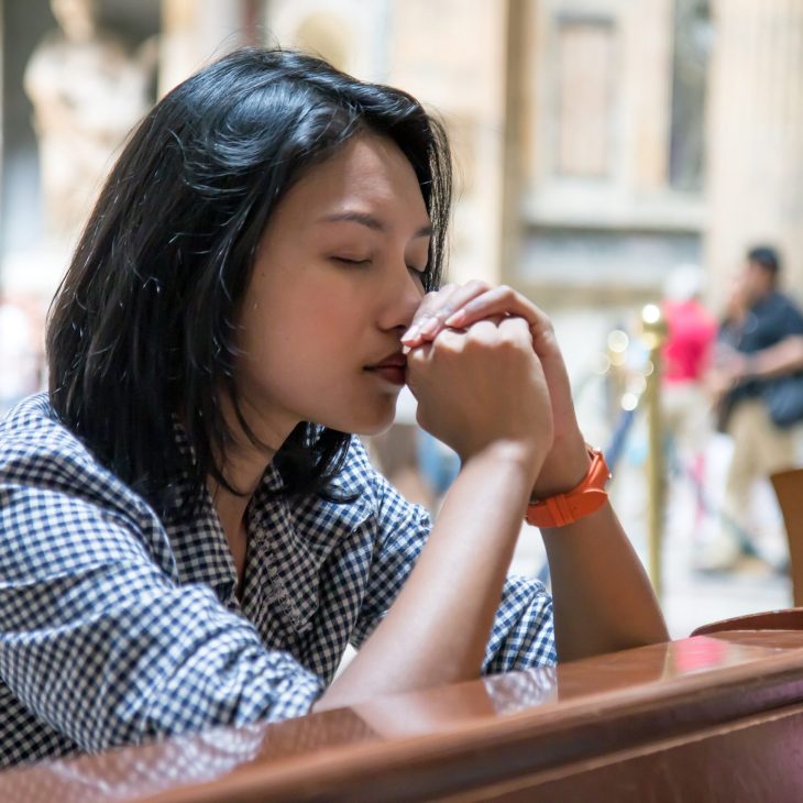 Woman praying in a church.