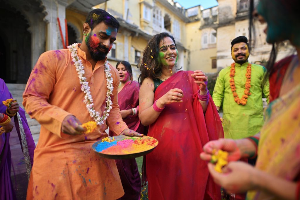 People dancing and celebrating Holi festival with a plate full of colors. Holi is a Hindu festival, a festival of colors. (Mayur Kakade/Getty Images)
