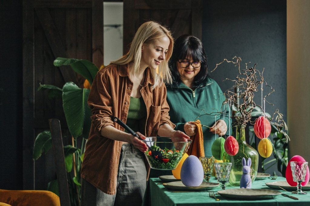 People setting table for Easter dinner at home (Westend61/Getty Images)