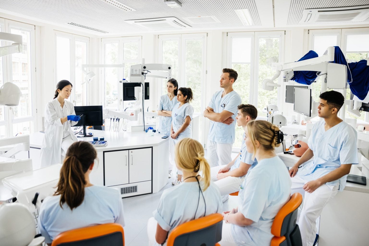 A group of students listening to their teacher together in a modern university laboratory. (Tom Werner/Getty Images)