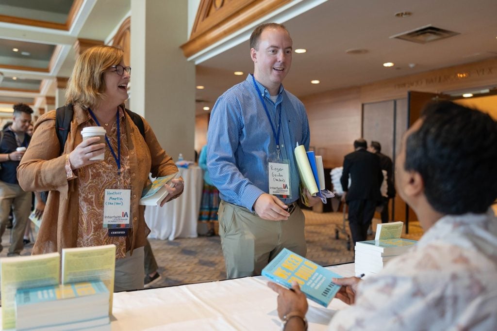 Eboo Patel signs a copy of We Need to Build: Field Notes for Diverse Democracy at the 2023 Interfaith Leadership Summit.