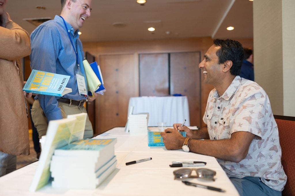 Eboo Patel signs a copy of We Need to Build: Field Notes for Diverse Democracy at the 2023 Interfaith Leadership Summit.