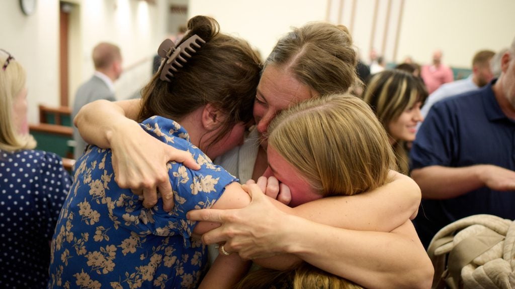 Members of the Grand Blanc, Michigan, congregation of The Church of Jesus Christ of Latter-day Saints embrace each other following the meeting with Elder David A. Bednar of the Quorum of the Twelve Apostles on Tuesday, September 30, 2025, following the deadly shooting and fire that claimed four lives and injured eight others at a local meetinghouse of The Church of Jesus Christ of Latter-day Saints. (2025 by Intellectual Reserve, Inc. All rights reserved.)