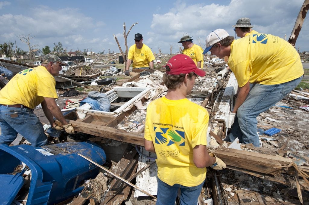 JOPLIN, MO- JUNE 18: Members of the Church Of Jesus Christ Of Latter Day Saints, of Independence, Kansas, attempt to lift a toppled wall while clearing the remains of a home on June 18, 2011, in Joplin, Missouri. More than 28,000 volunteers have made their way to Joplin to help clear debris in the weeks following an EF5 tornado that leveled parts of the city.  (Photo by Julie Denesha/Getty Images)