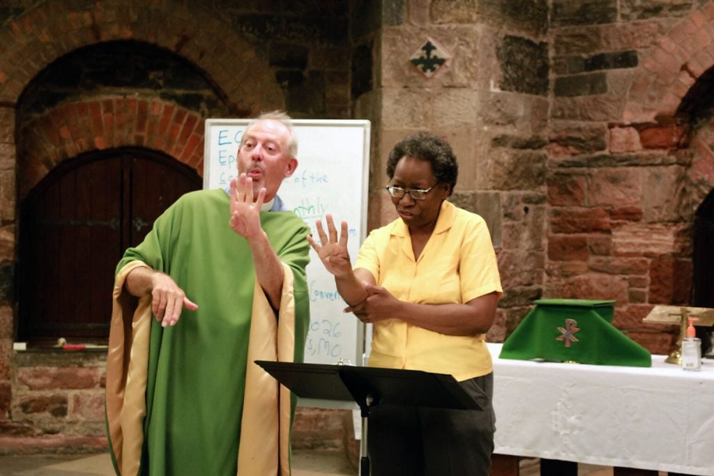 The Rev. Erich Anderson-Krengel, left, and Melissa Inniss sign with attendees at St. Ann’s Church for the Deaf, Sunday, Aug. 17, 2025, in New York City. (Photo by Leyrian Colón Santiago)