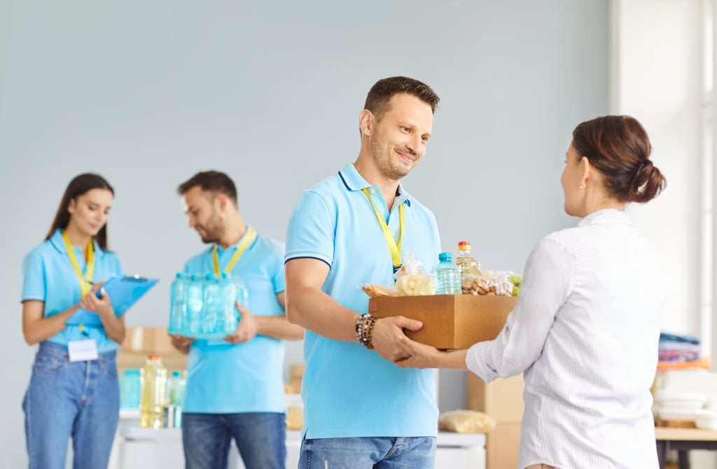Volunteers passing a box of food. (Getty / Studio Romantic)