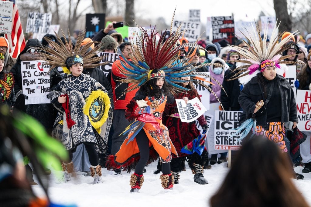 MINNEAPOLIS, MINNESOTA - JANUARY 10: Indigenous dancers perform as people gather for a march to memorialize Renee Nicole Good and against the influx of federal agents in the city at Powderhorn Park on January 10, 2026 in Minneapolis, Minnesota. Good was fatally shot by an immigration enforcement agent during an incident in south Minneapolis on January 7. (Photo by Stephen Maturen/Getty Images)