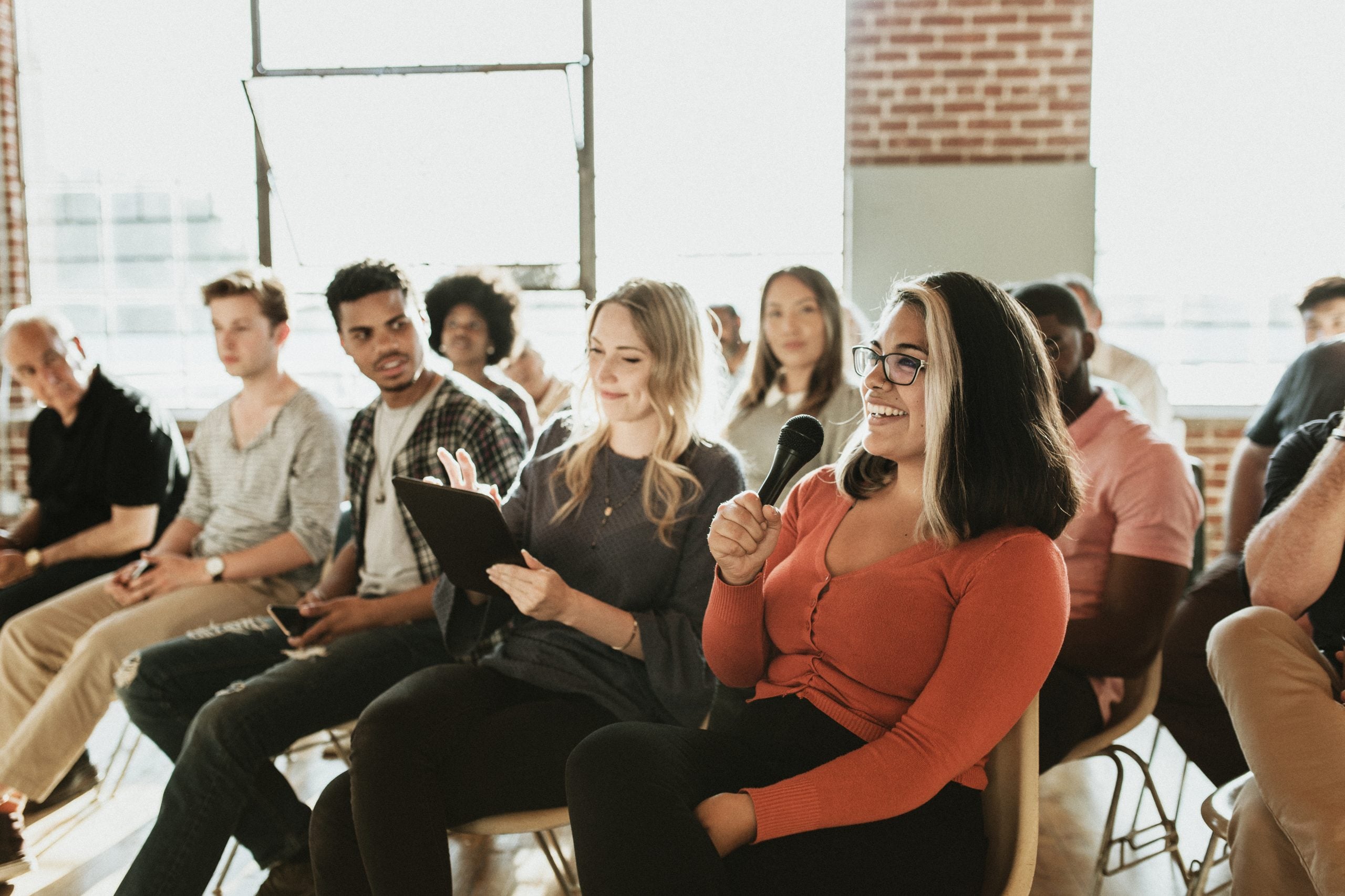 Person speaking on a microphone in a town hall meeting. (iStock / Getty Images Plus)