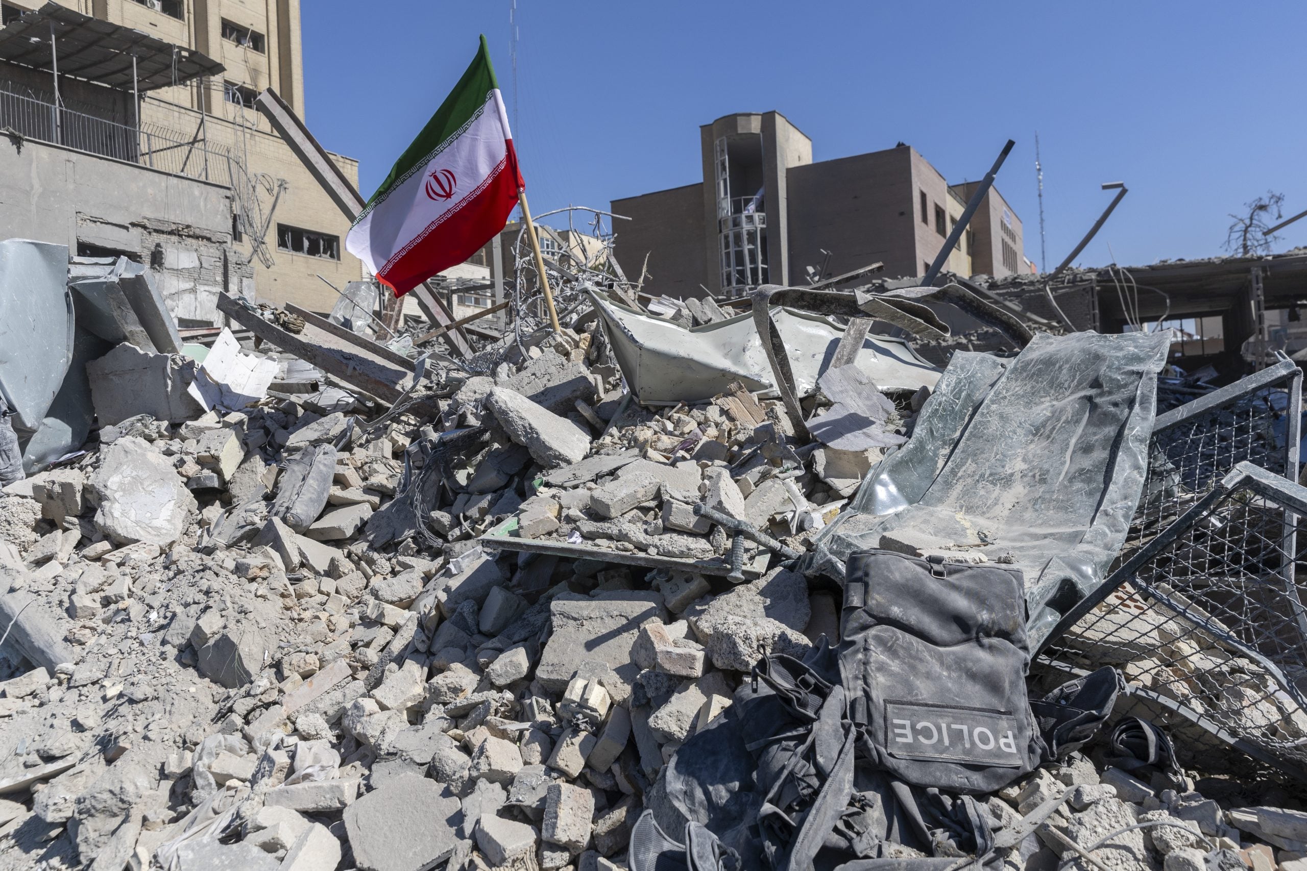 TEHRAN, IRAN - MARCH 3: An Iranian flag is planted in the rubble of a police station, damaged in airstrikes yesterday, on March 3, 2026 in Tehran, Iran. The United States and Israel have continued the joint attack on Iran that began on February 28, resulting in the death of Iran's Supreme Leader, Ayatollah Ali Khamenei. Iran retaliated by firing waves of missiles and drones at Israel, and targeting U.S. allies in the region. (Photo by Majid Saeedi/Getty Images)
