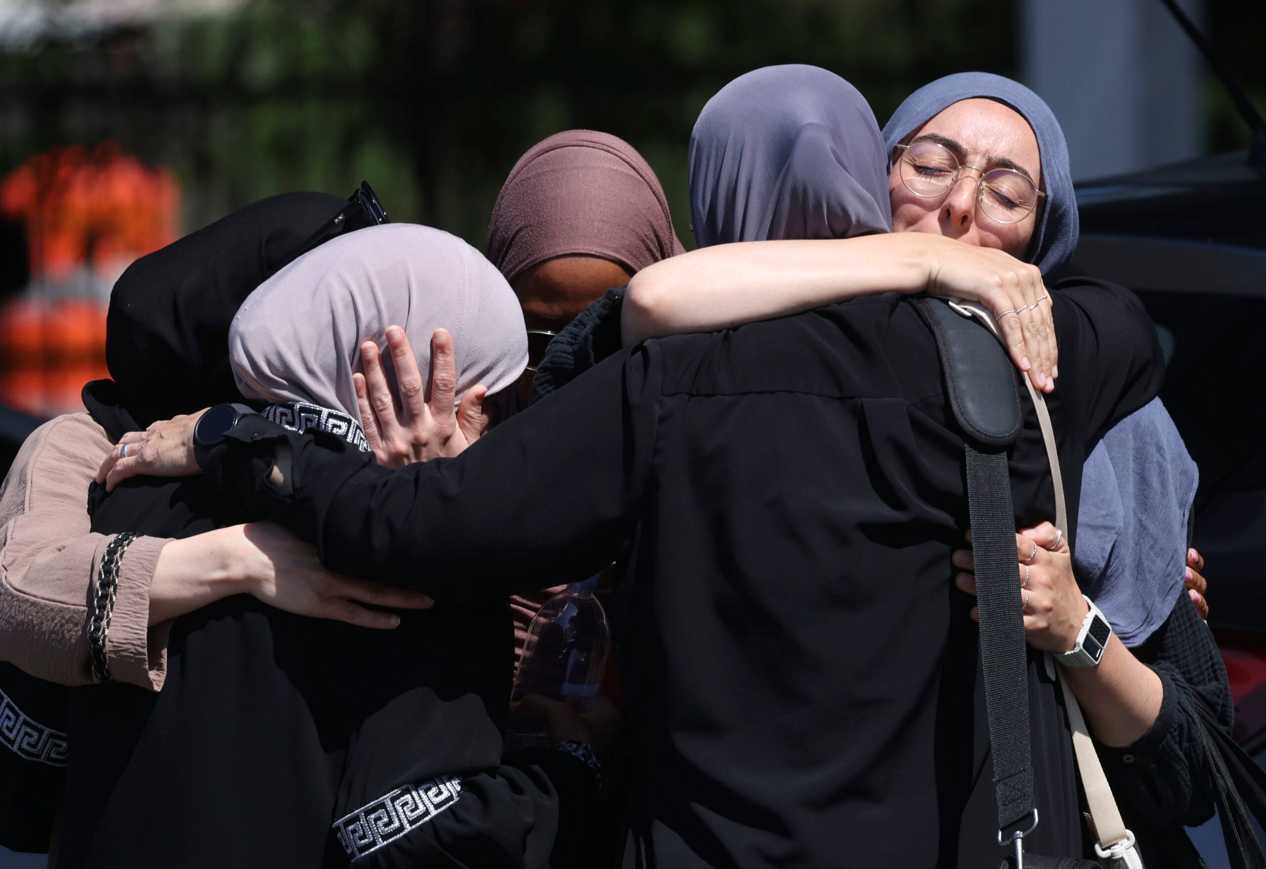 SAN DIEGO, CALIFORNIA - MAY 19: Mosque members embrace in the parking lot of the Islamic Center of San Diego (ICSD) on May 19, 2026 in San Diego, California. Three people were killed and two suspects are dead after a shooting at San Diego's largest mosque. (Photo by Sandy Huffaker/Getty Images)