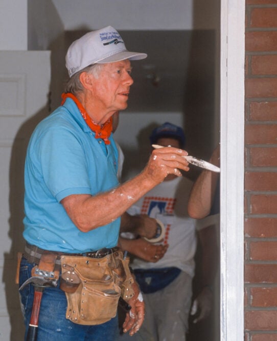 WASHINGTON, DC, USA - JUNE 18, 1992: President Jimmy Carter, Habitat for Humanity, painting door frame during project on Benning Road. (Rob Crandall/Shutterstock)