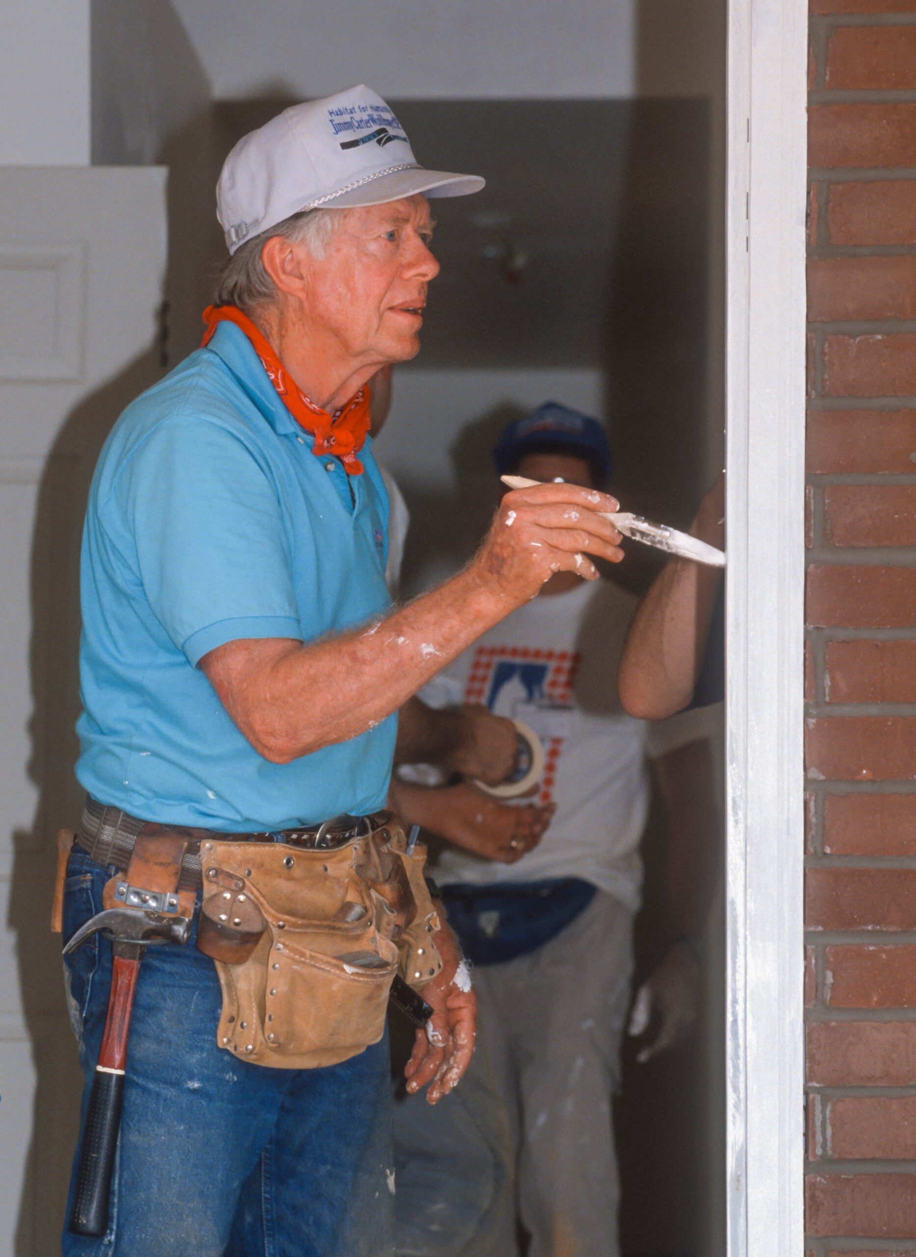 WASHINGTON, DC, USA - JUNE 18, 1992: President Jimmy Carter, Habitat for Humanity, painting door frame during project on Benning Road. (Rob Crandall/Shutterstock)