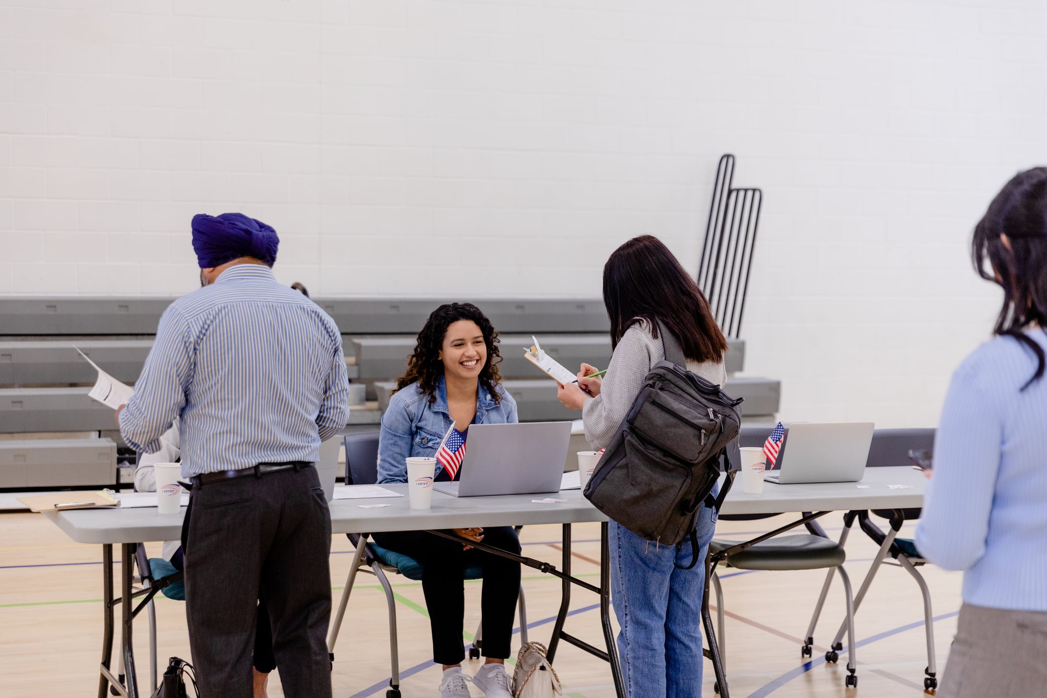 Volunteers help voters sign in and receive their ballots. (	SDI Productions/Getty)