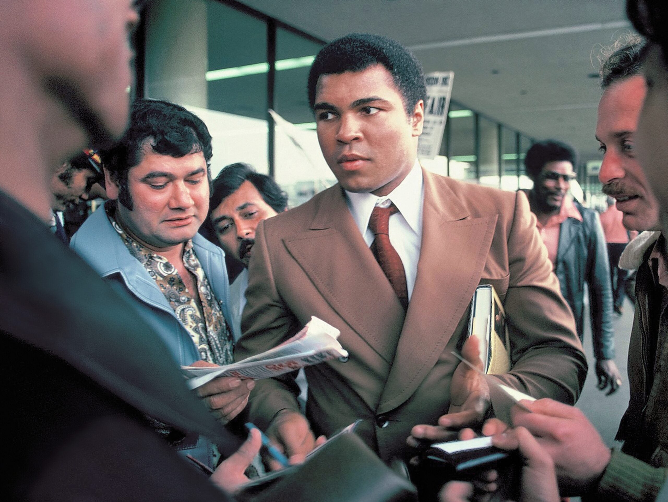 SAN ANTONIO, TEXAS - MARCH 10, 1979: Muhammad Ali signs autographs for fans at the San Antonio International Airport. (Scott Woodham Photography/Shutterstock)