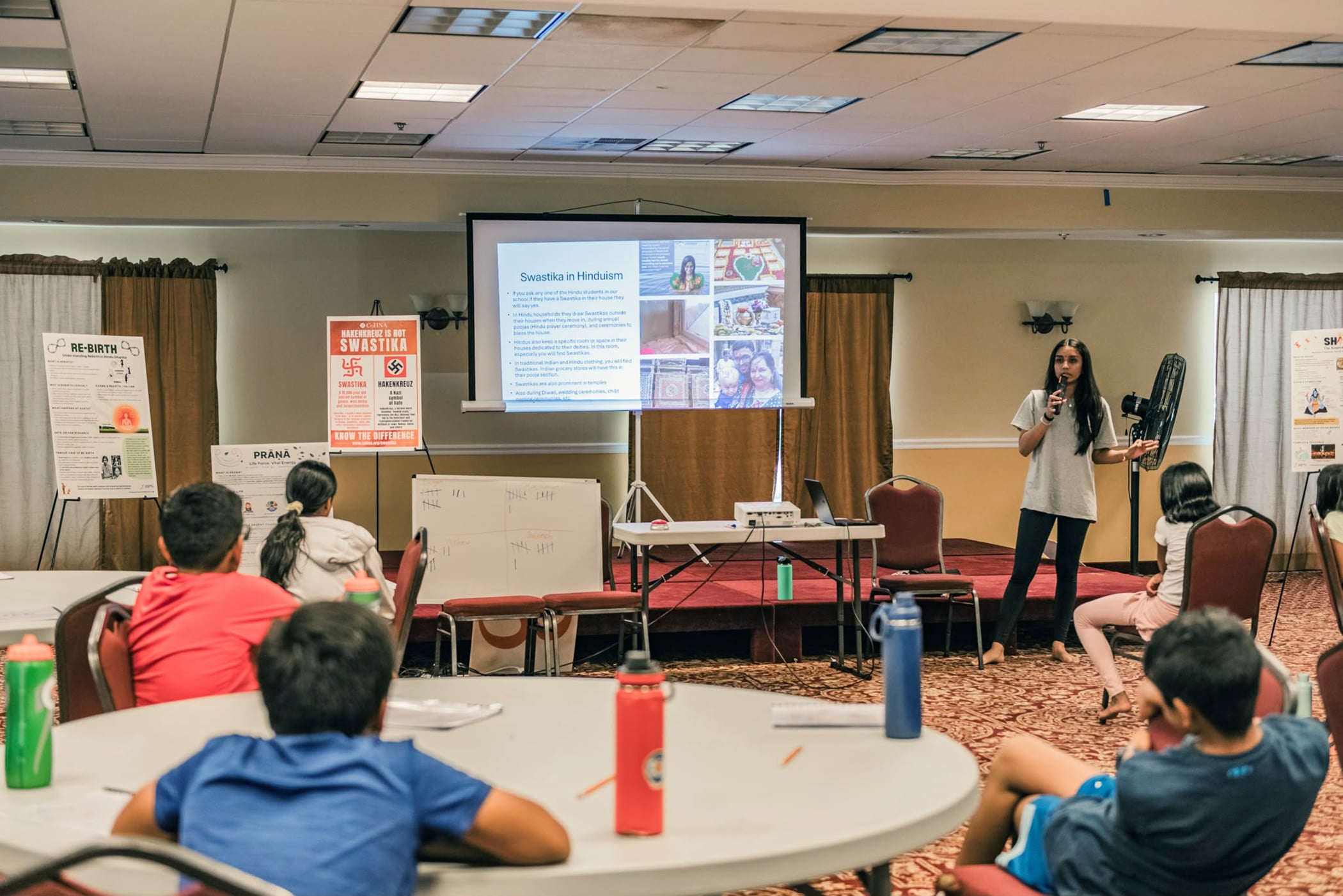 Mira Trivedi, right, presents a lesson about swastika history to kids. (Photo courtesy of Mira Trivedi)