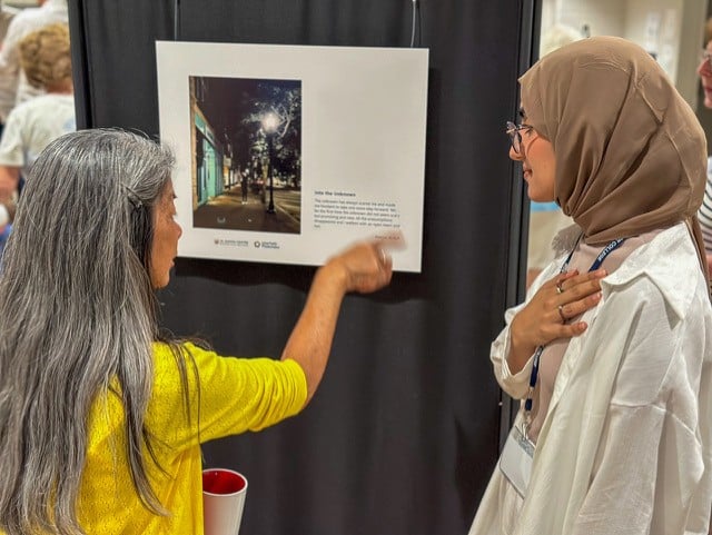 An exhibition featuring students from Oman who visited the U.S. participated a photovoice project during their trip and had an exhibit at the end of the visit. Left to right: Guest of the exhibition and partipant, Rawan Al Aufi. Photo credit: Roman Williams