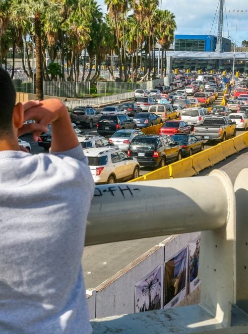 Tijuana, Mexico, Dec 13 - A man looks at the long line of cars who are waiting in Mexico to cross the border between the United States and Mexico at the San Ysidro station, the most transited border point between the United States and Mexico.  (Photo Beto/Getty Images)